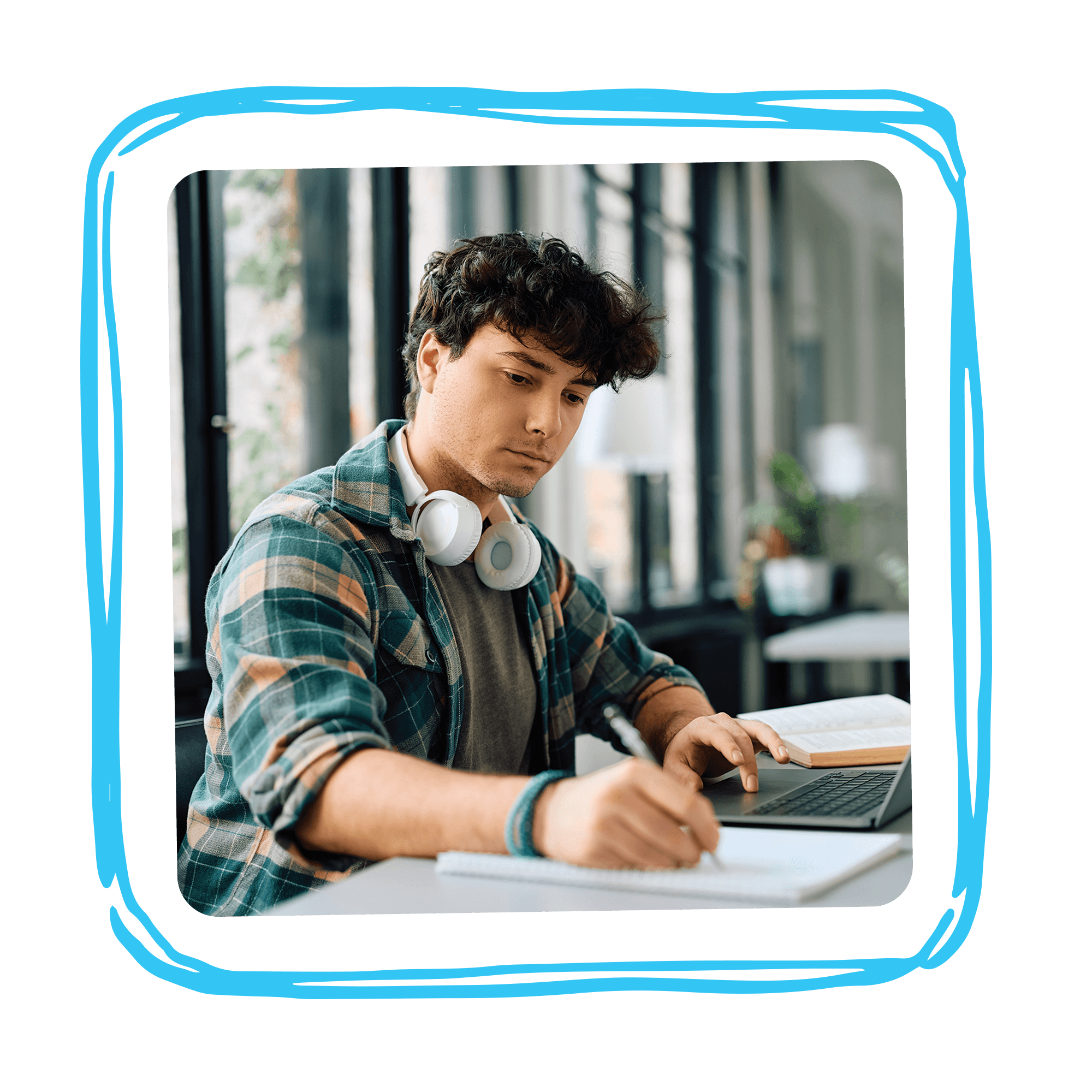 A law student writing notes beside an open laptop