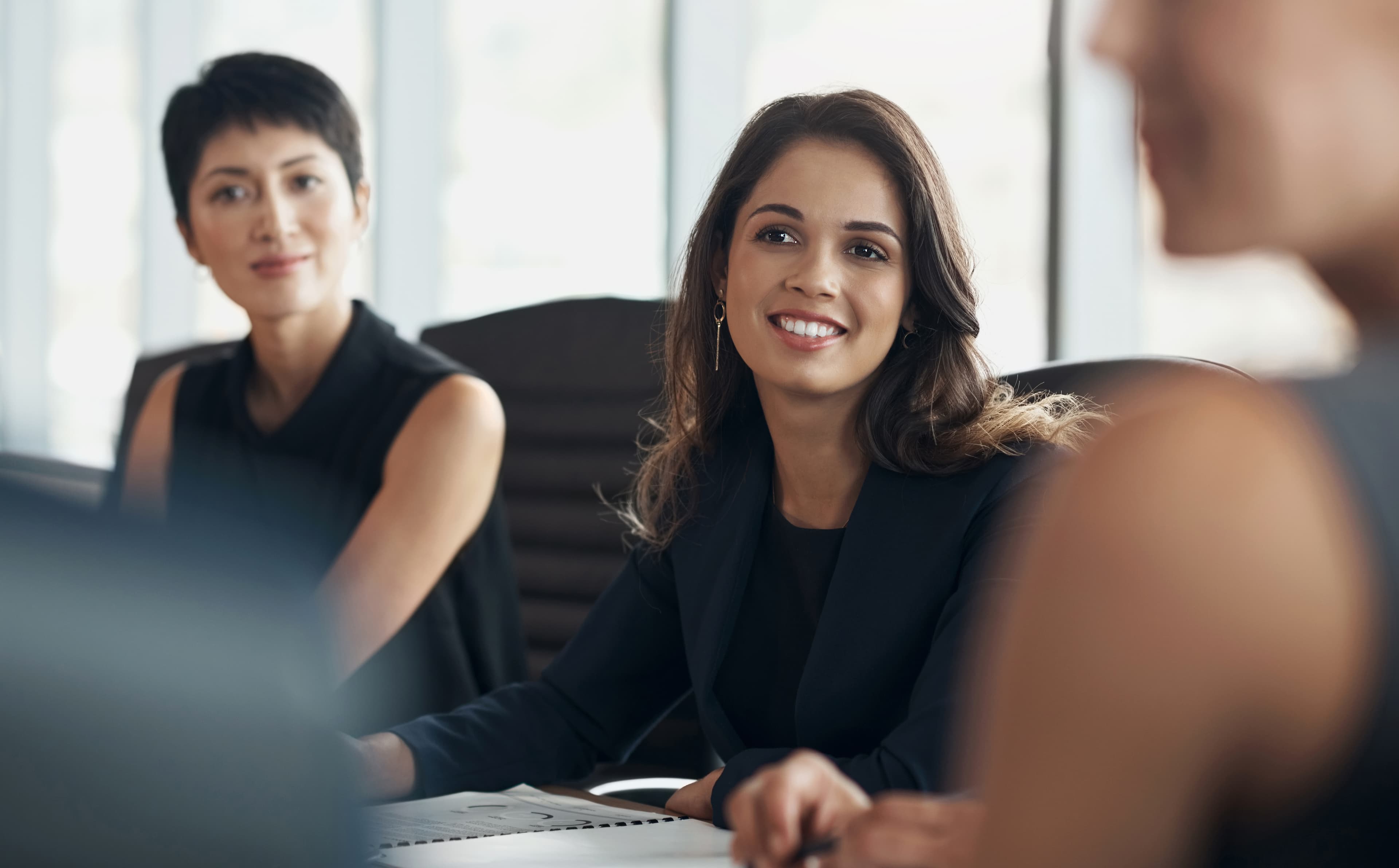 A smiling student working at a desk in a bright office